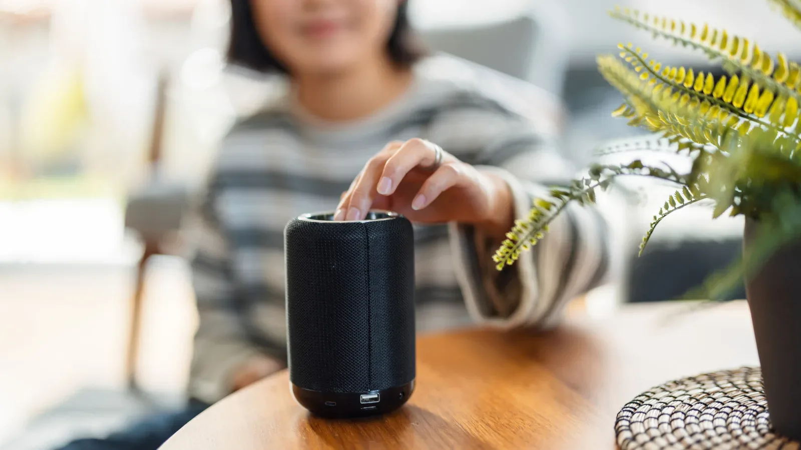 A portable Bluetooth speaker on a table beside a phone, illustrating RMS wattage and loudness comparisons