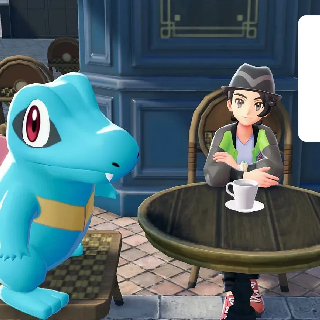 A Totodile and trainer look up from a table with a coffee cup, with a GamesRadar+ Prime Day deals badge in the top right-hand corner of the frame