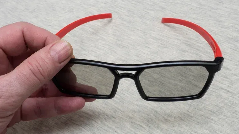 A person holding IMAX 3D glasses.