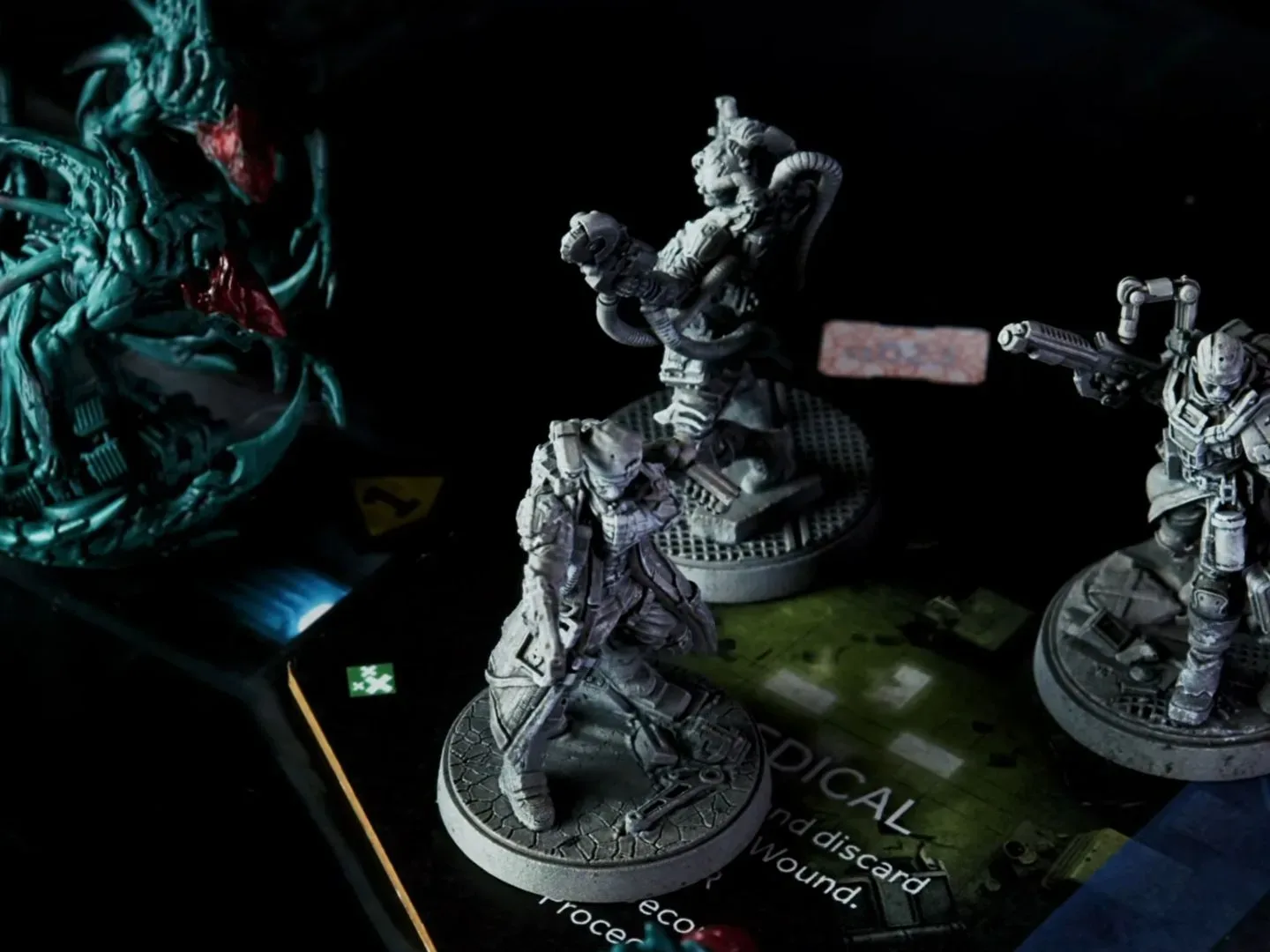 Miniatures from Nemesis Legacy face each other in a dark environment